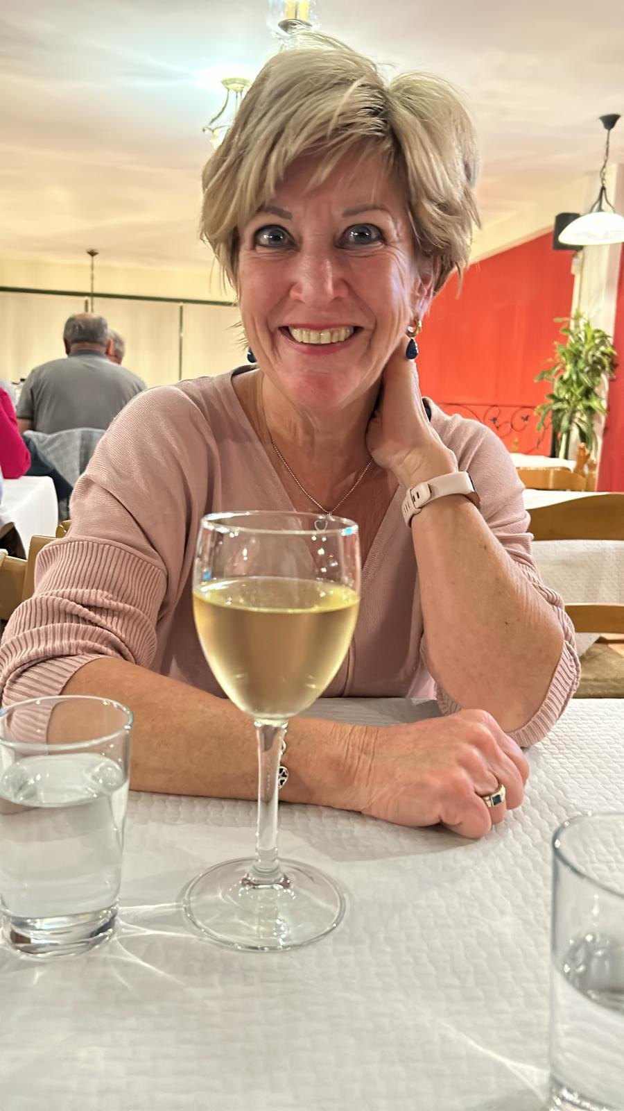 Fanny Eijdems aan tafel met een glas witte wijn